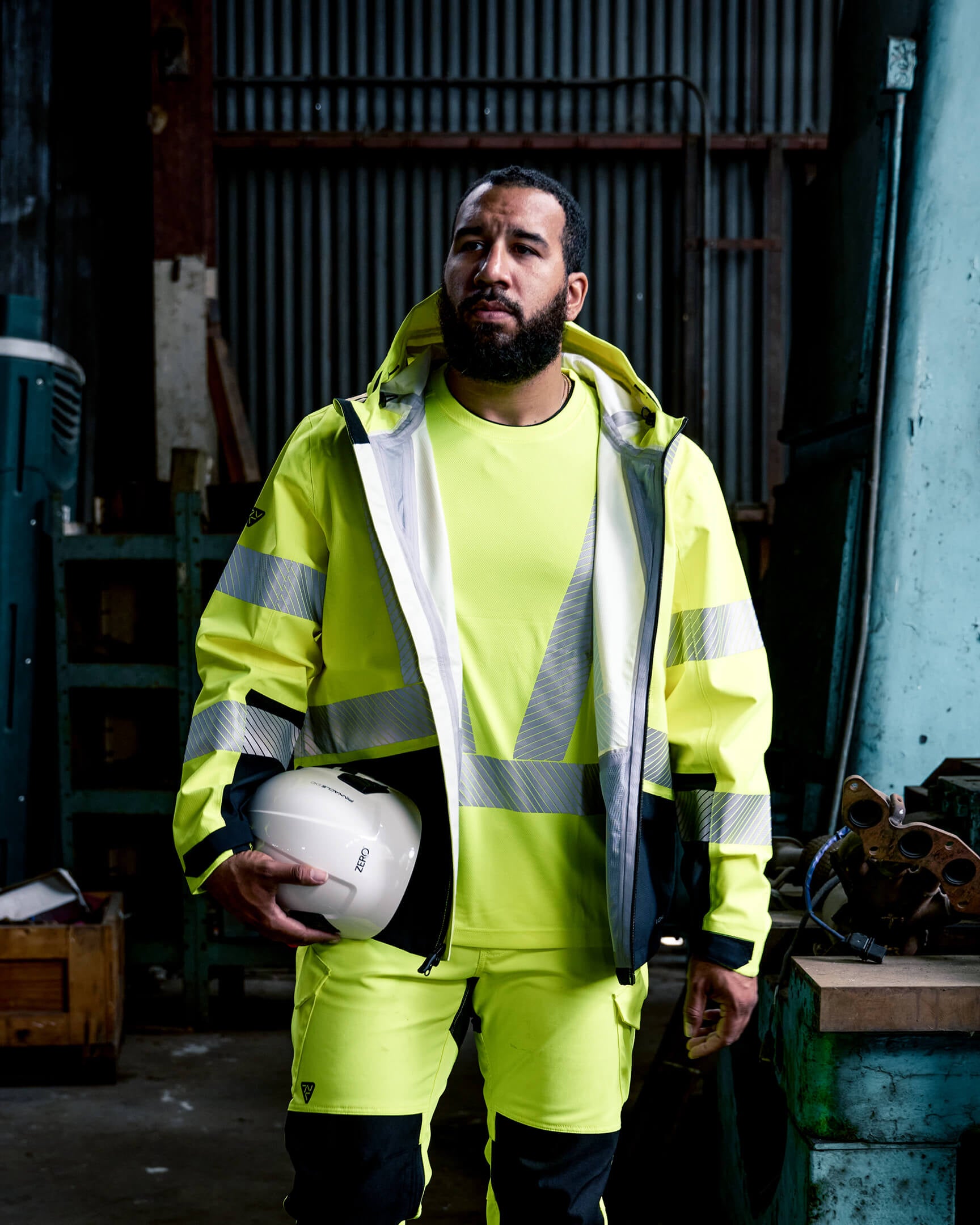 Worker wearing the VOHL Hi Vis Waterproof Shell Jacket – Safety Yellow while seated outdoors, showcasing weather protection and mobility | color:safety-yellow