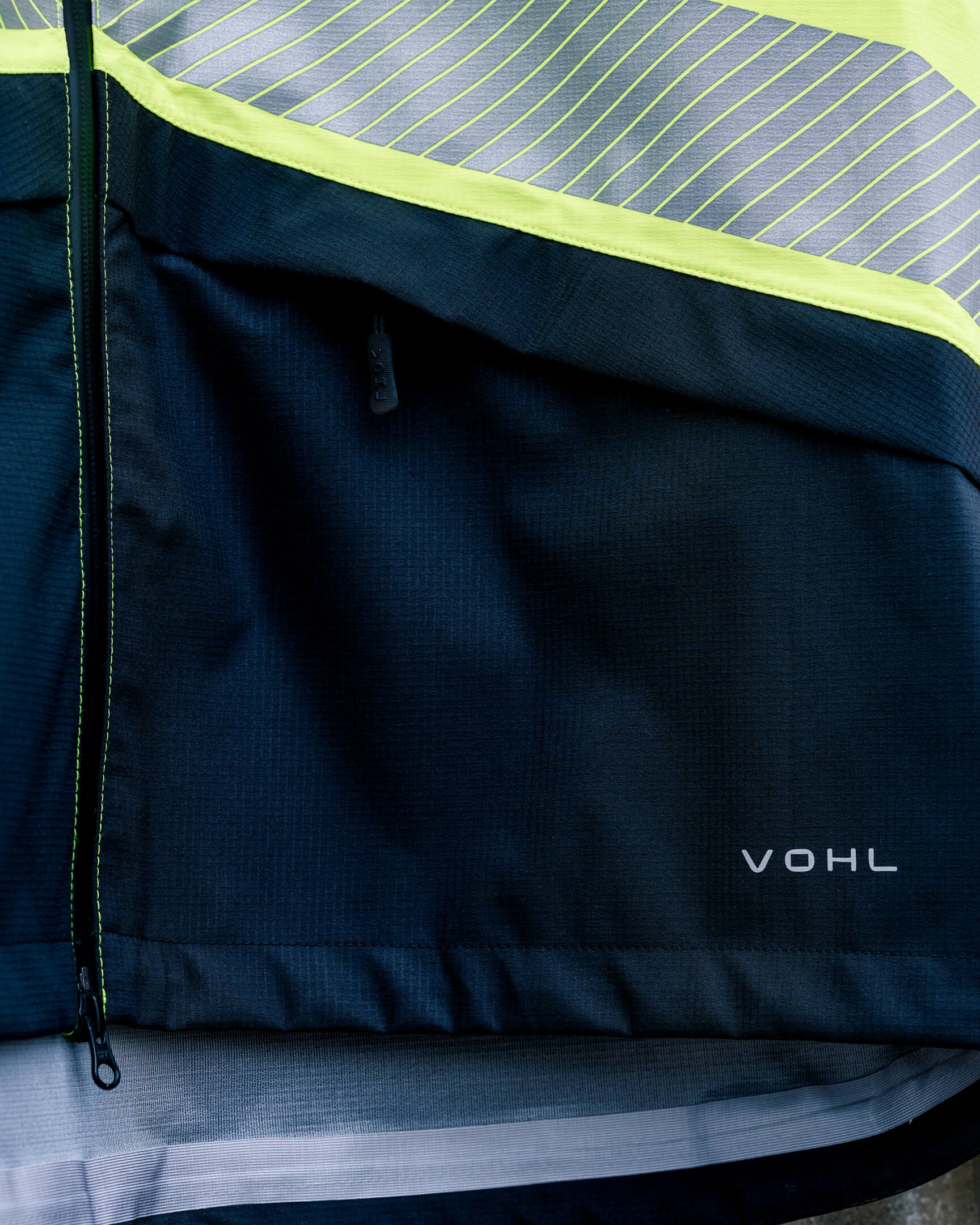 Close-up of the VOHL Hi Vis Waterproof Shell Jacket – Safety Yellow showing technical construction and reflective sleeve detailing | color:safety-yellow