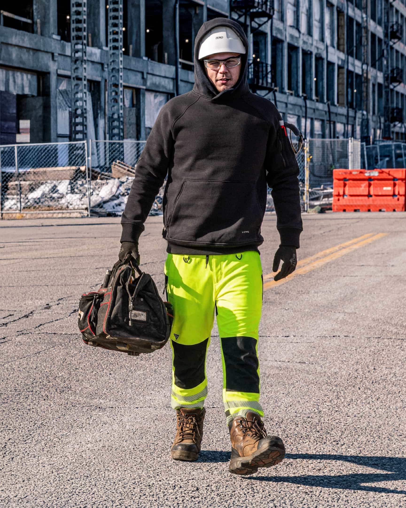 Men’s hi-vis yellow waterproof shell work pants with reflective tape and reinforced knees, worn on construction site – SKU HV-SP-105 | color:safety-yellow