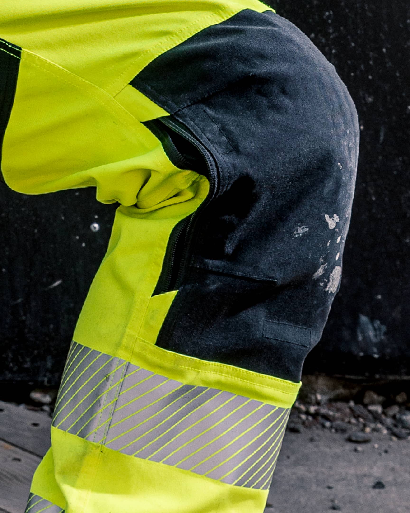 VOHL Hi Vis Utility Pant – Safety Yellow featuring reinforced knee panels and reflective lower-leg bands in a product lifestyle image | color:safety-yellow