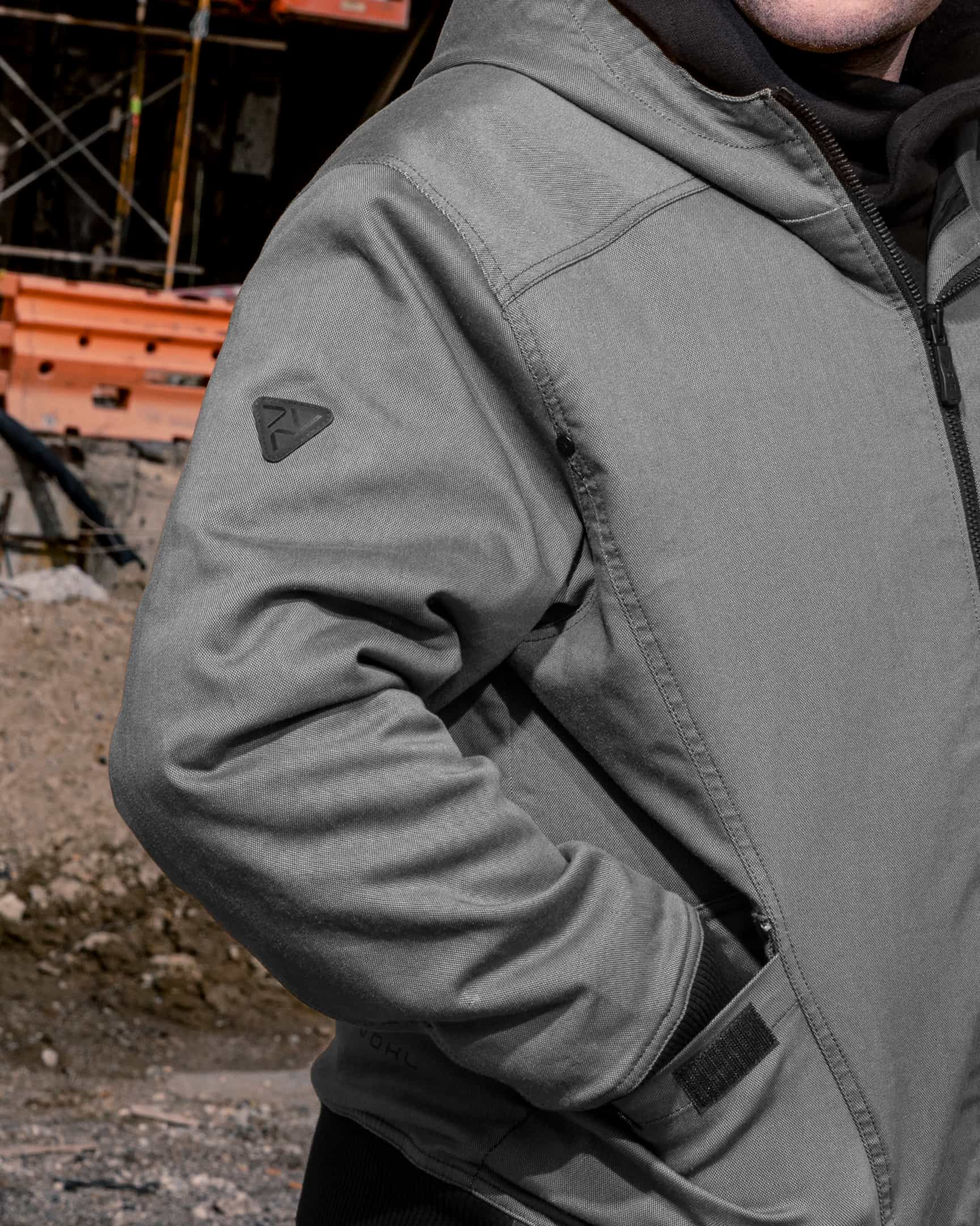 Close-up of pewter quilted lined work jacket sleeve with logo detail and pocket – SKU WW-UJ-700 | color:pewter