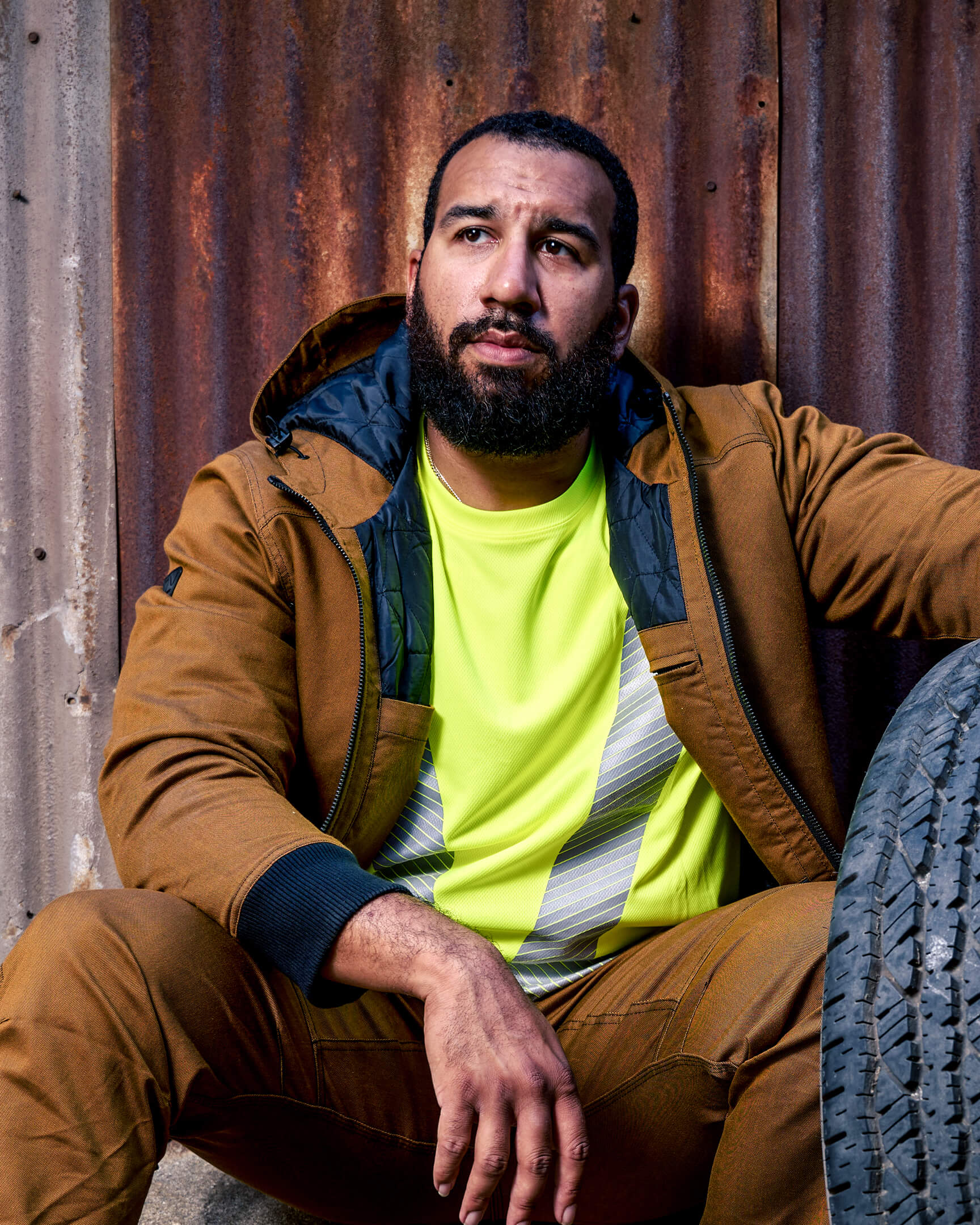 Worker wearing the VOHL Quilted Lined Jacket – Tobacco over a hi-vis shirt, demonstrating warmth and everyday durability | color:tobacco